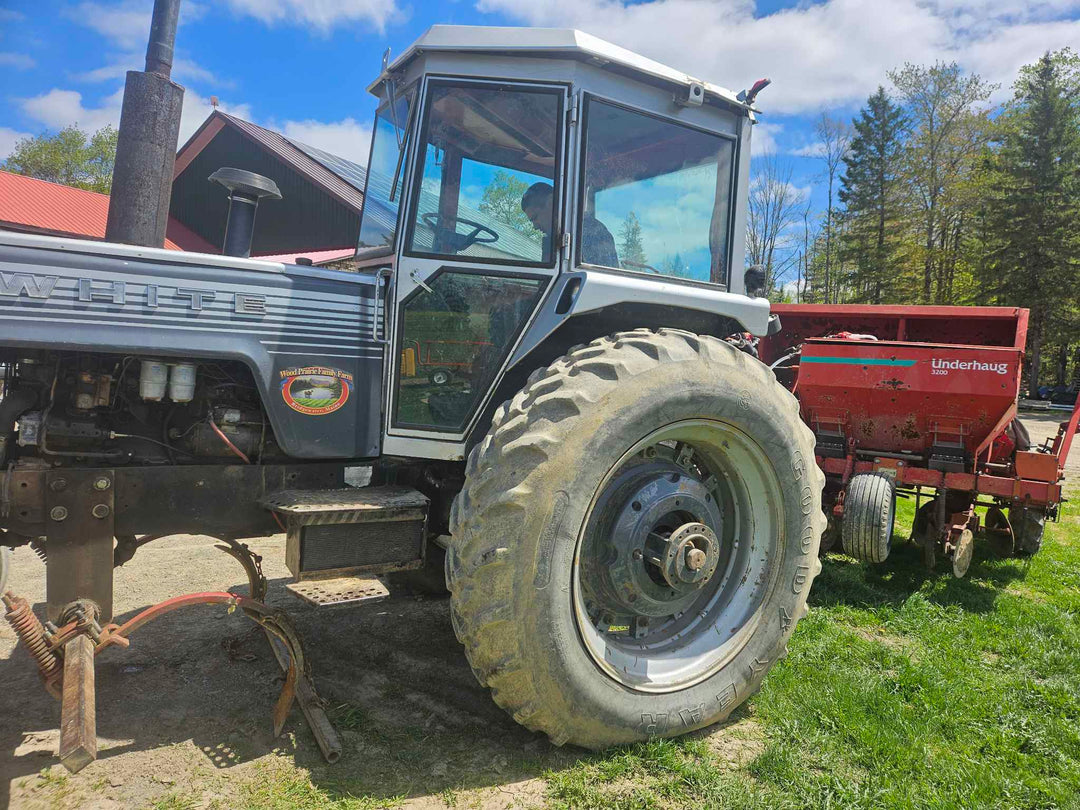 Caleb in the tractor towing the new (to us) potato planter.